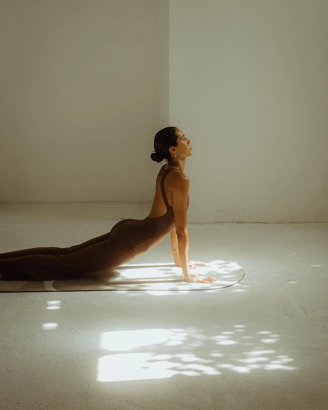 Mujer estirándose sobre una esterilla con luz natural